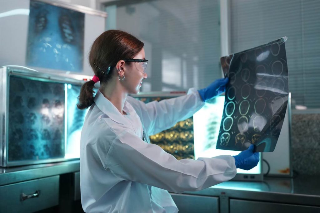 Das Bild zeigt eine sitzende Ärztin, die Röntenbilder auswertet. Symbolisch steht das Bild für die awisto CRM Branchenlösung Medizintechnik.